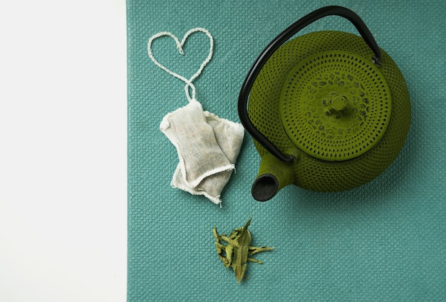 Lemon Verbena tea in teabag with heart shaped string  and teapot. Top View. Flat Lay