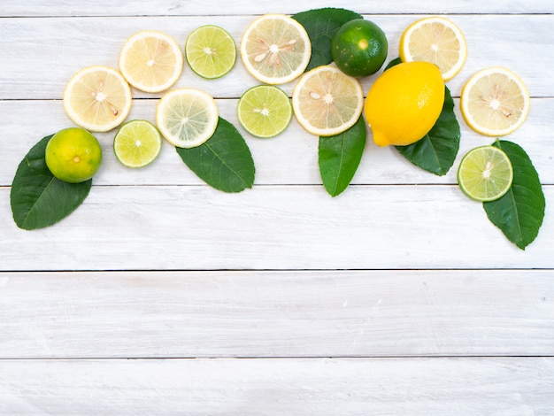 Lemon with leaves on white wooden background