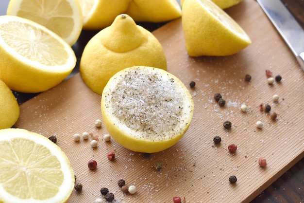 Lemon with salt and pepper on a bamboo chopping board