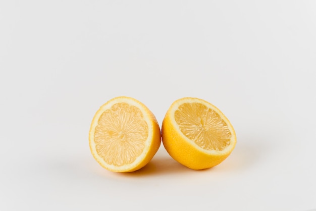 Lemon with water drops on white surface