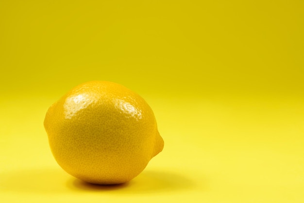 Lemon on yellow background with copy space Closeup
