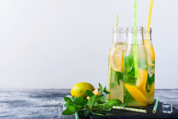 Lemonade in bottles with ice and mint 