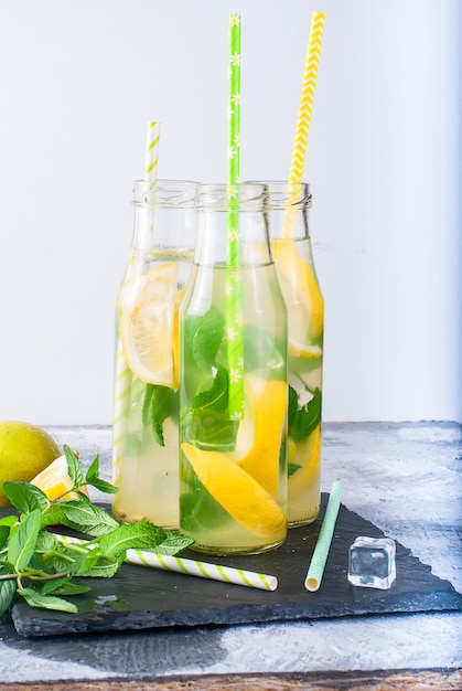 Lemonade in bottles with ice and mint 