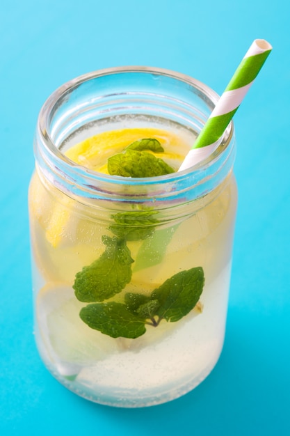 Lemonade drink in a jar glass on blue