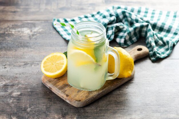 Lemonade drink in a jar glass and ingredients on wooden table