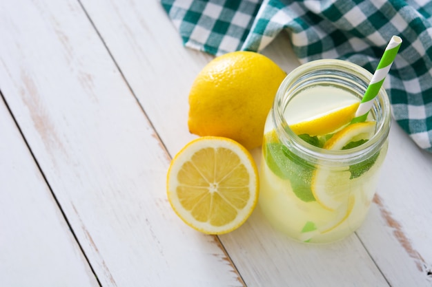 Lemonade drink in a jar glass on white wood.