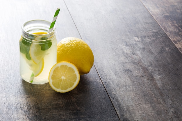 Photo lemonade drink in a jar glass on wood.