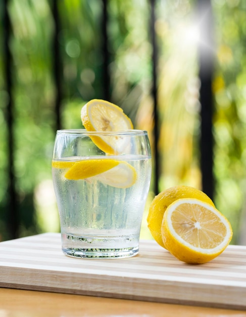 Lemonade and fresh lemons on wooden table