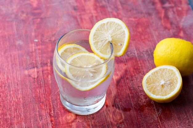 Lemonade and fresh lemons on wooden table