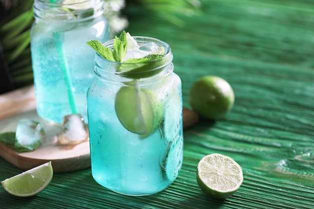 Lemonade from lime and mint in a glass jar on a table