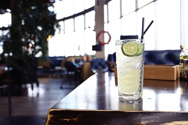 lemonade in glass cafe / fresh lemonade with ice and lime in a glass on a restaurant background