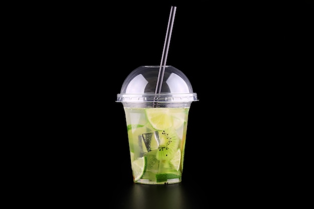 Lemonade to go cup with mint, lime and kiwi on black space, isolated