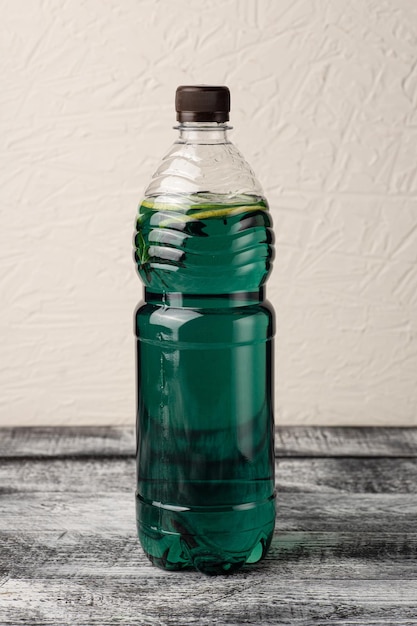 Lemonade homemade lemonade in a bottle on a white wooden background