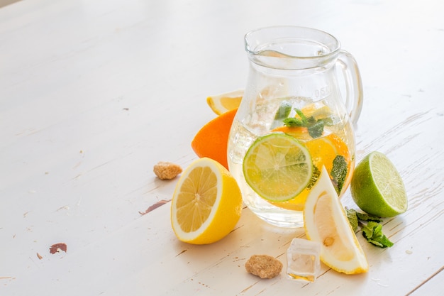 Lemonade and ingredients on white wood background