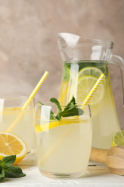 Lemonade and ingredients on wooden table. Fresh drink