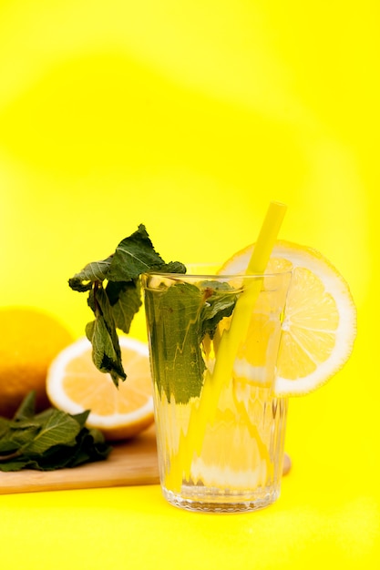 Lemonade made from organic fruits over yellow background