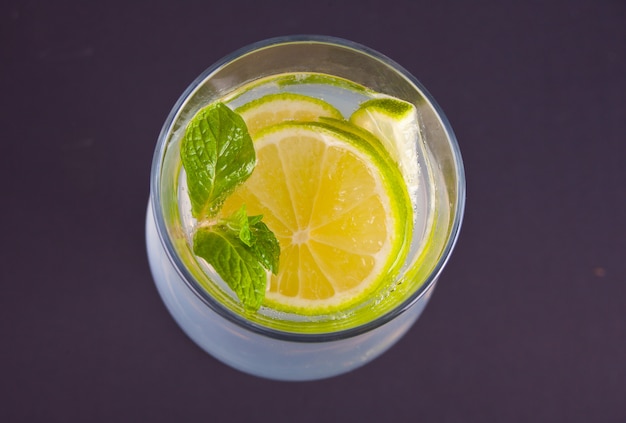 Lemonade or mojito cocktail with lemon and mint, cold refreshing drink or beverage. Top view.