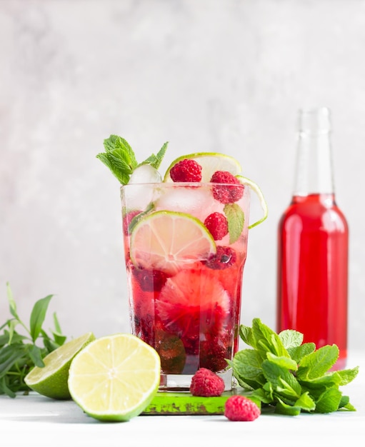 Foto limonata o cocktail senza alcol con lime di lamponi e menta in bicchiere di bacca estiva