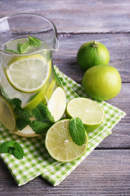 Lemonade in pitcher on wooden background