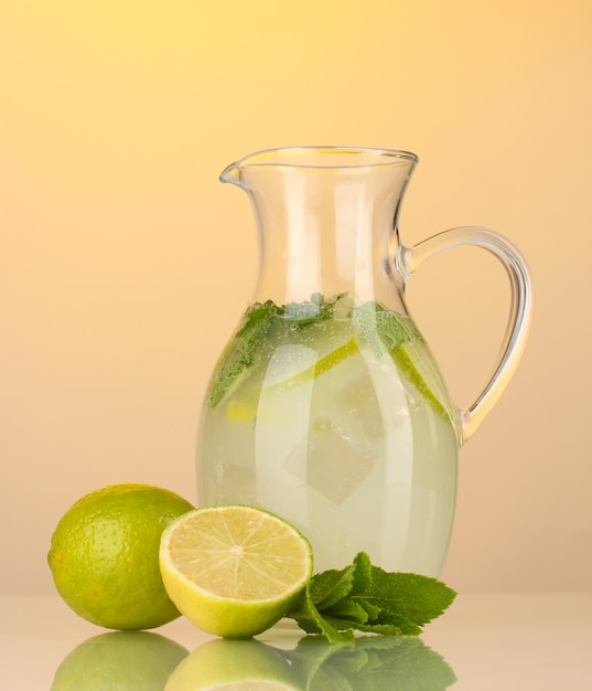 Lemonade in pitcher on yellow background