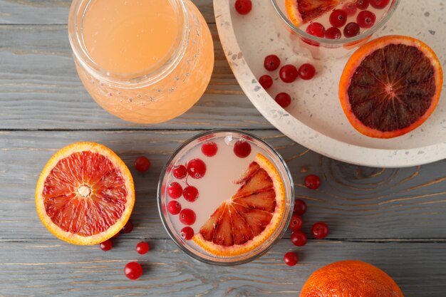 Lemonade, red orange and cranberry on wooden surface