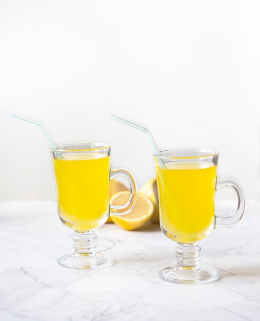 Lemonade refreshing drink in a glass beaker on a light background