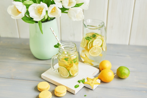 Lemonade, sweet macarons and tulip flowers