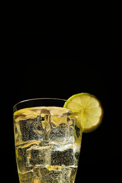 Lemonade with ice on dark background