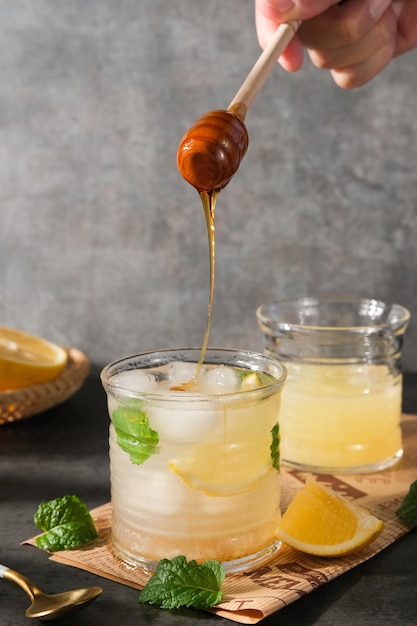 Lemonade with ice in fancy glass with mint leaf selected focus