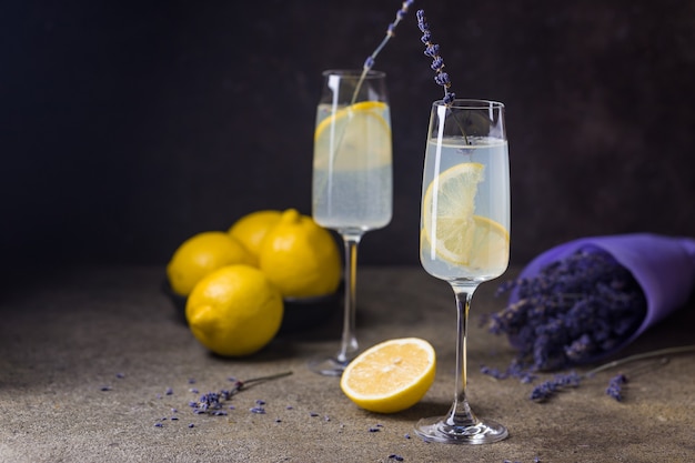 Lemonade with lemons and lavender on black stone table