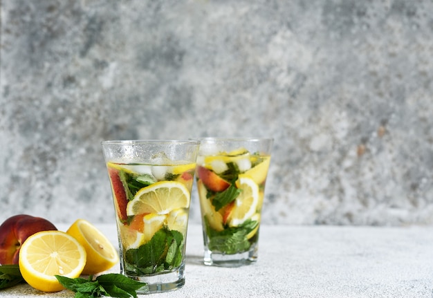 Lemonade with peach and mint in a glass cup  . Peach lemonade.