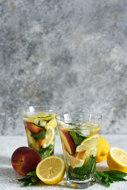 Lemonade with peach and mint in a glass cup  . Peach lemonade.