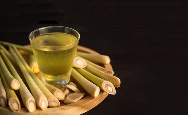 lemongrass juice in glass on wooden plate with black