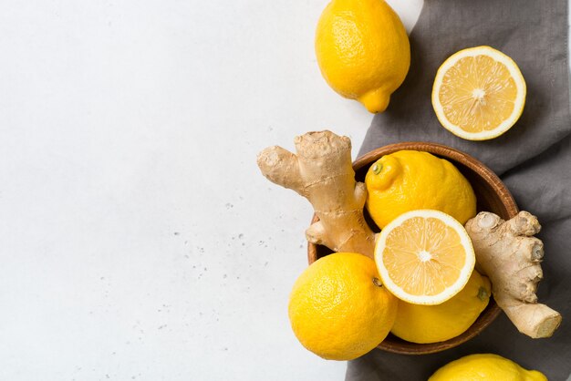 Lemons and ginger in bowl on a white. top view