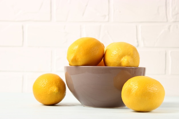 Lemons and green leaves on a colored background