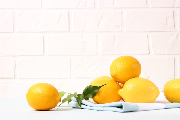 Lemons and green leaves on a colored background