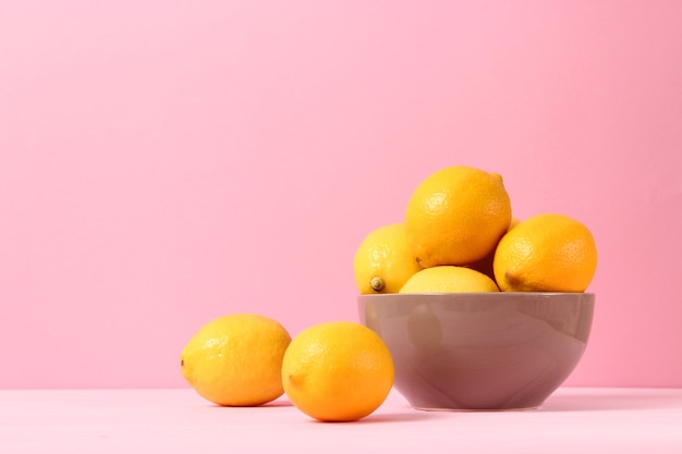 Lemons and green leaves on a colored background