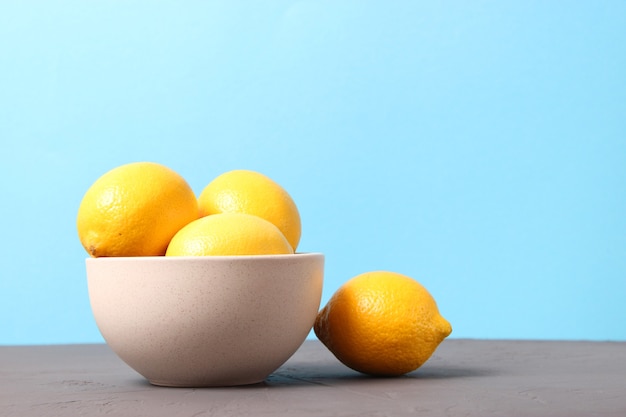 Lemons and green leaves on a colored background