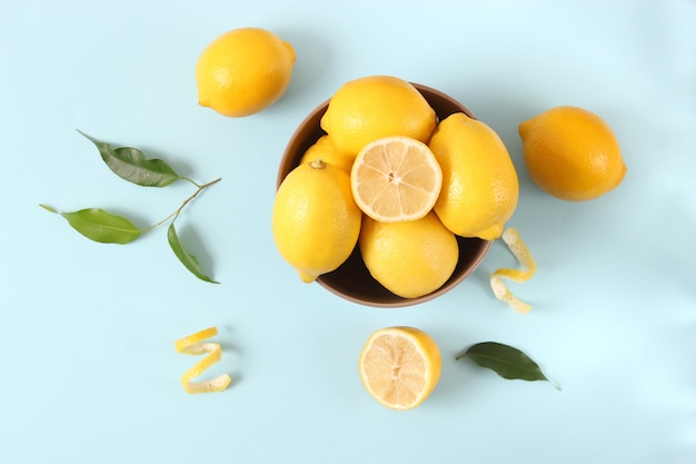 Lemons and green leaves on a colored background