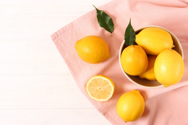 Lemons and green leaves on a colored background