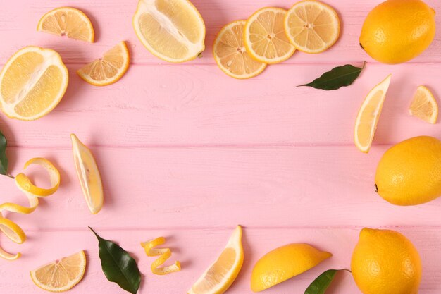 Lemons and green leaves on a colored background