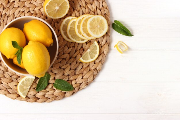 Lemons and green leaves on a colored background