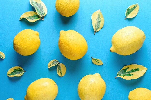 lemons and green leaves isolated on blue