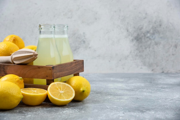 Lemons grey backround lemon juice and fresh on cutting board