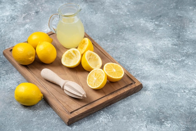 Lemons grey backround lemon juice and fresh on cutting board