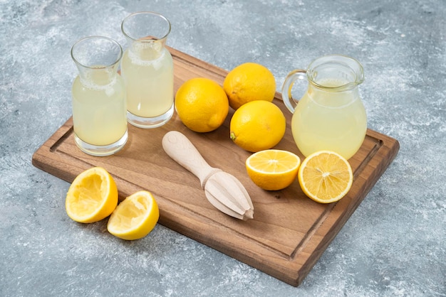 Lemons grey backround lemon juice and fresh on cutting board