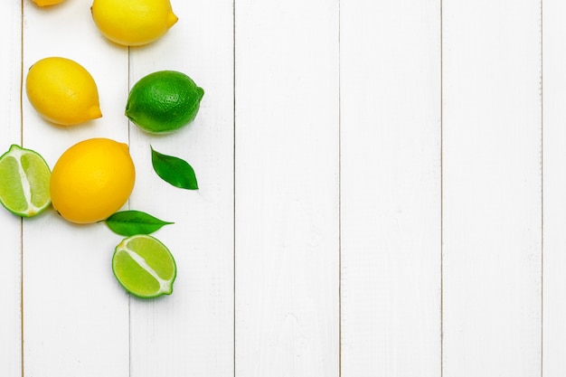 Lemons and limes on a wooden background.