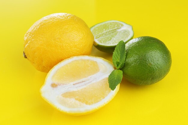 Lemons and limes on yellow background