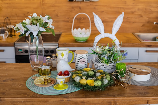 Lemons, olives, almonds on a wooden board and Easter eggs at the back