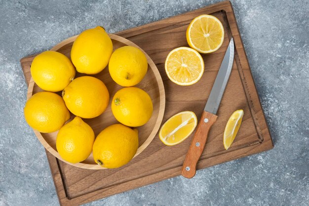 Lemons in wood bowl with cutting board